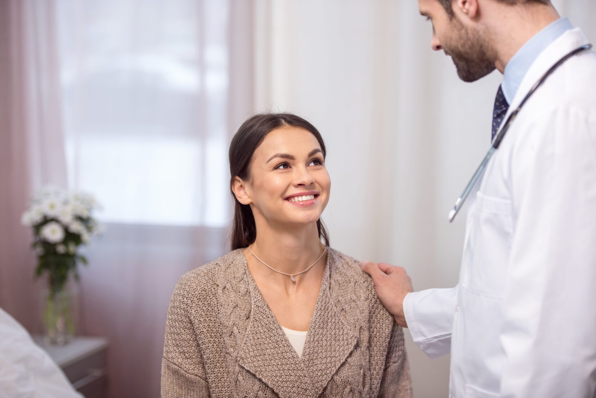Depositphotos_138446840_XL A woman is smiling as a doctor examines her chest