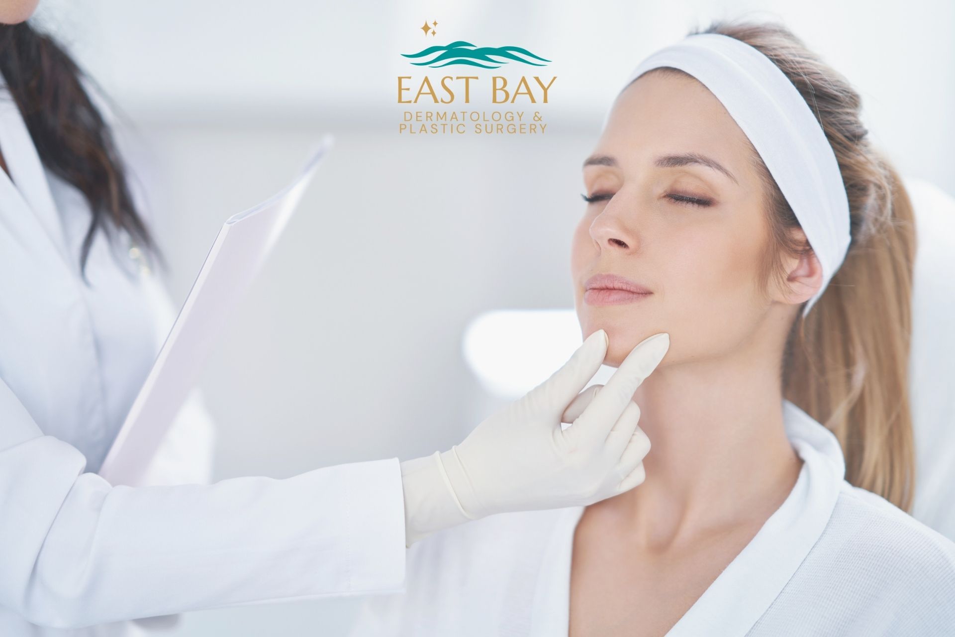 A woman sits with eyes closed while a medical professional in gloves examines her chin at East Bay Dermatology & Plastic Surgery, a leading medspa in Bellmore; the clinic’s logo is visible above.