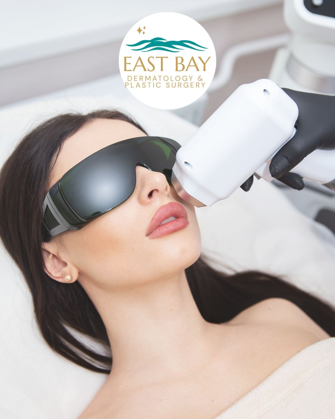 A woman wearing protective goggles receives a cosmetic facial treatment with a handheld device at a medspa in Bellmore's dermatology and plastic surgery clinic.